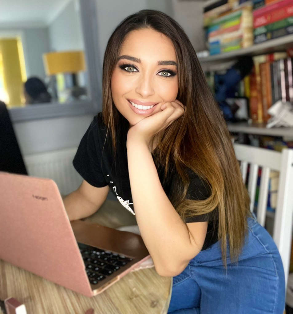 Ami Writes copywriter working on laptop and smiling at camera. 