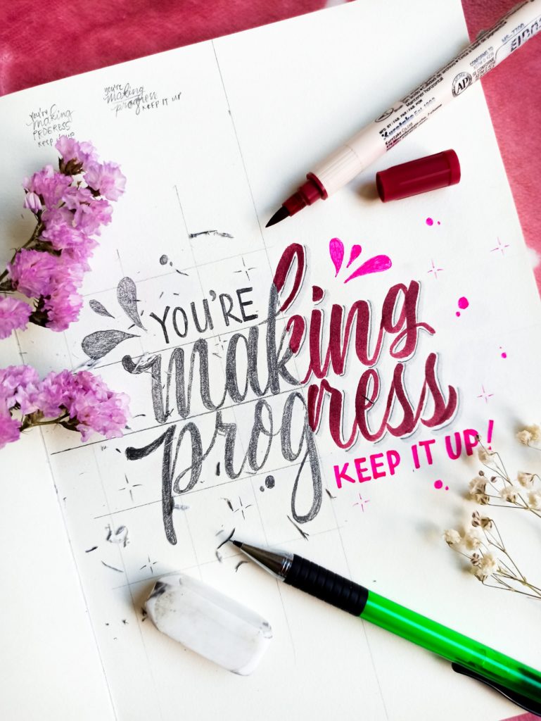 bright pink background with open notebook. Artwork and quote saying "you're making progress, keep it up!" with a pink flower beside it.