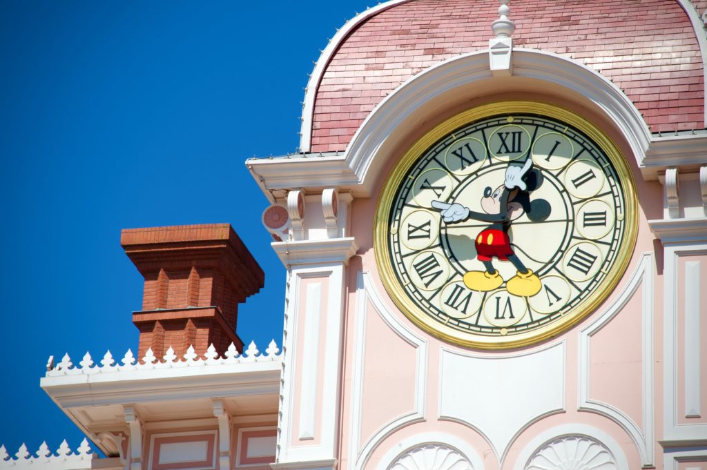 Pink clock-tower with Mickey Mouse in the center of the clock-face. At DisneyWorld. 