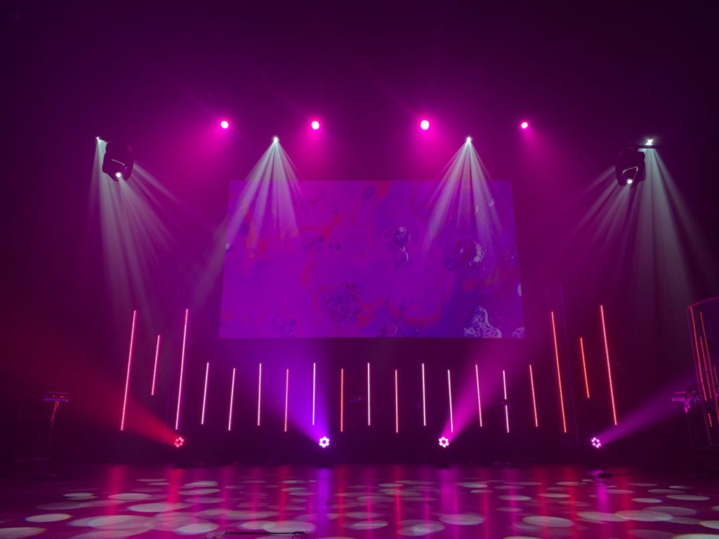 Pink and purple lighting on stage with spotlights